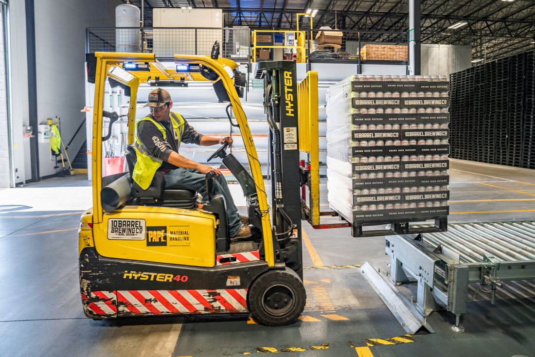 Forklift handling pallets in a logistics warehouse